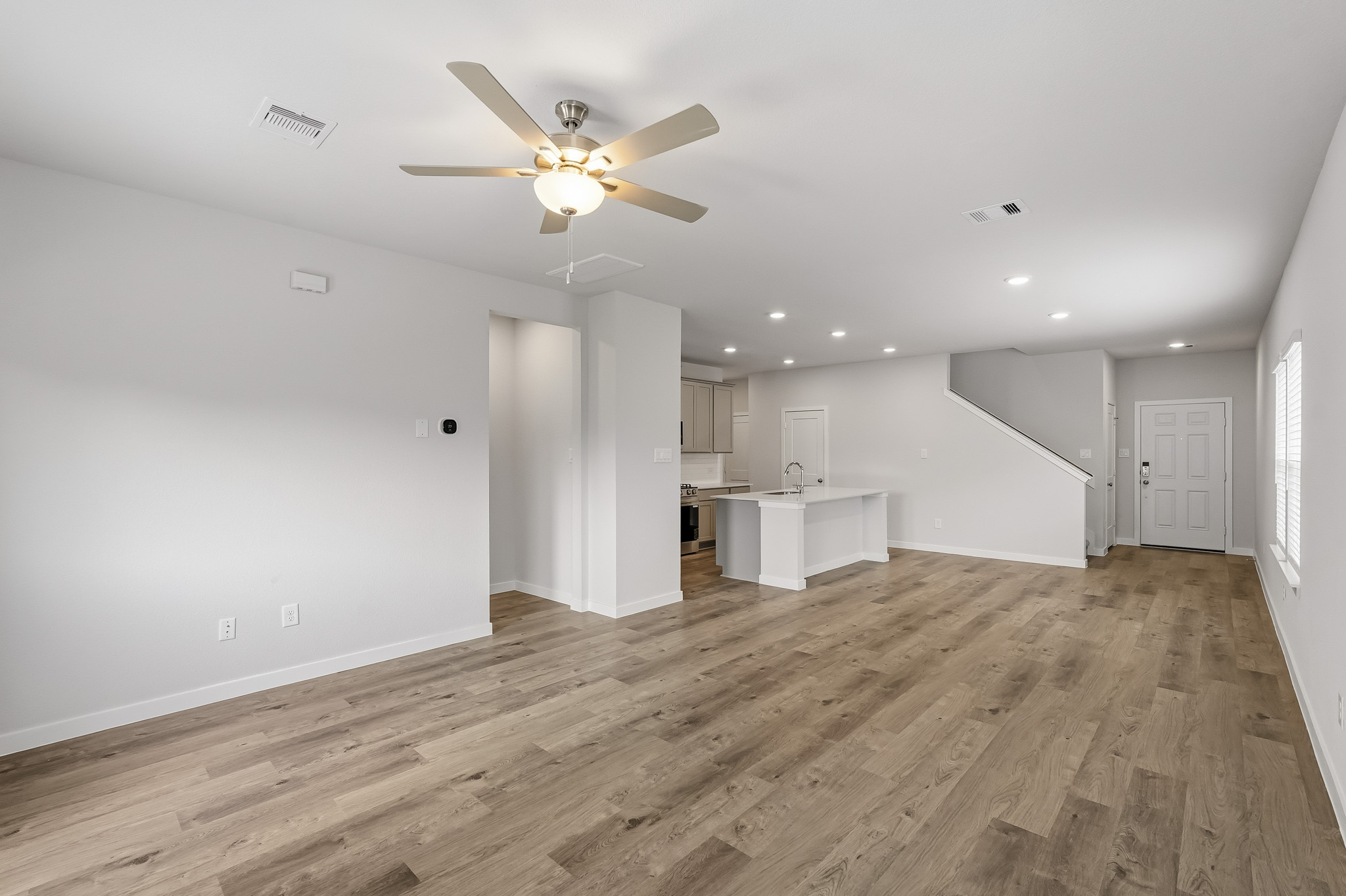 A room with a wood floor and a ceiling fan.