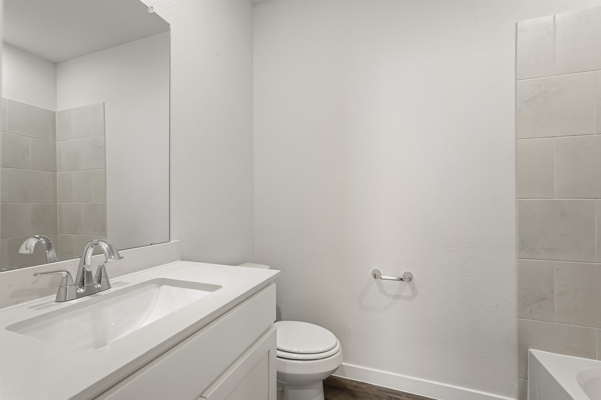 A bathroom with a sink toilet and mirror.