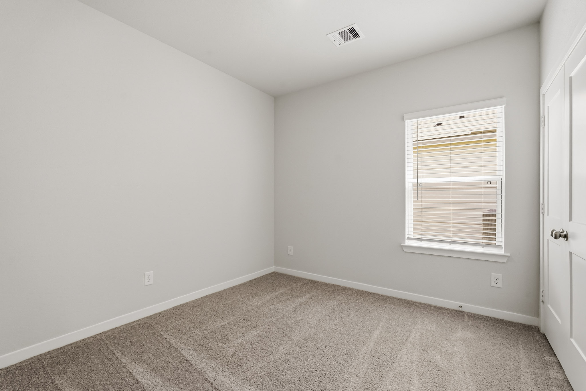 A room with a carpet and a window.