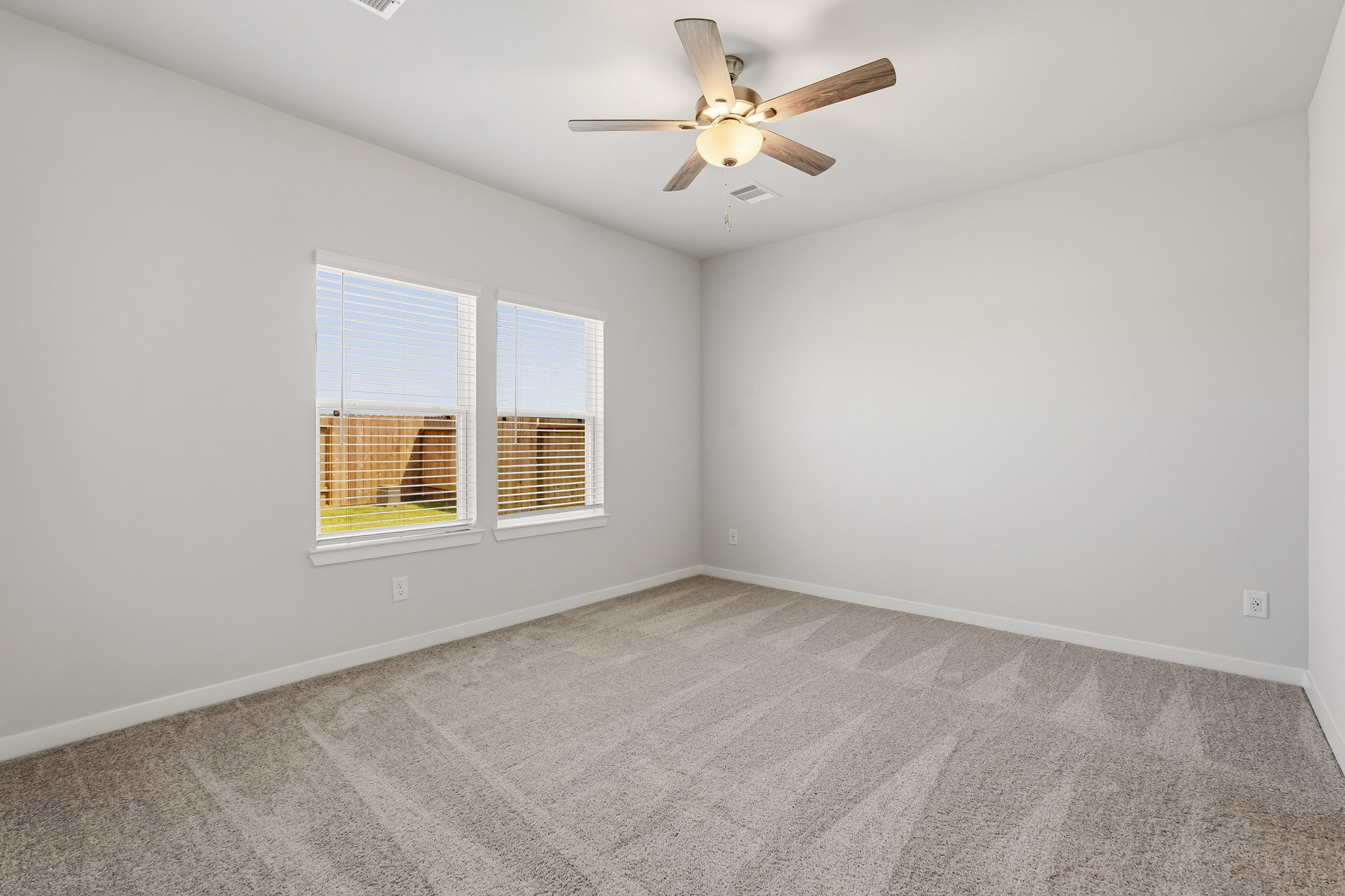 A room with a ceiling fan and a window.