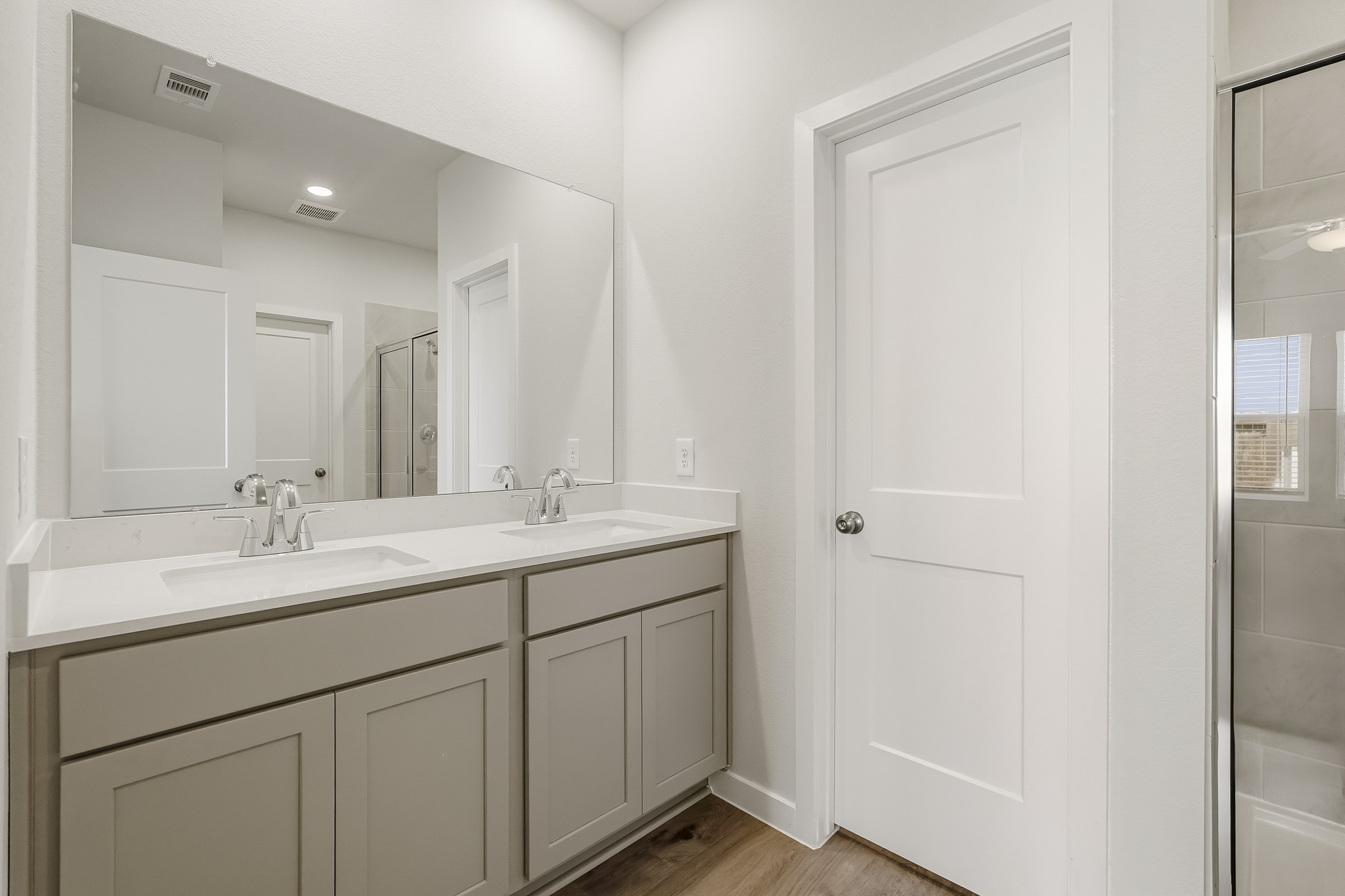 A bathroom with white cabinets.
