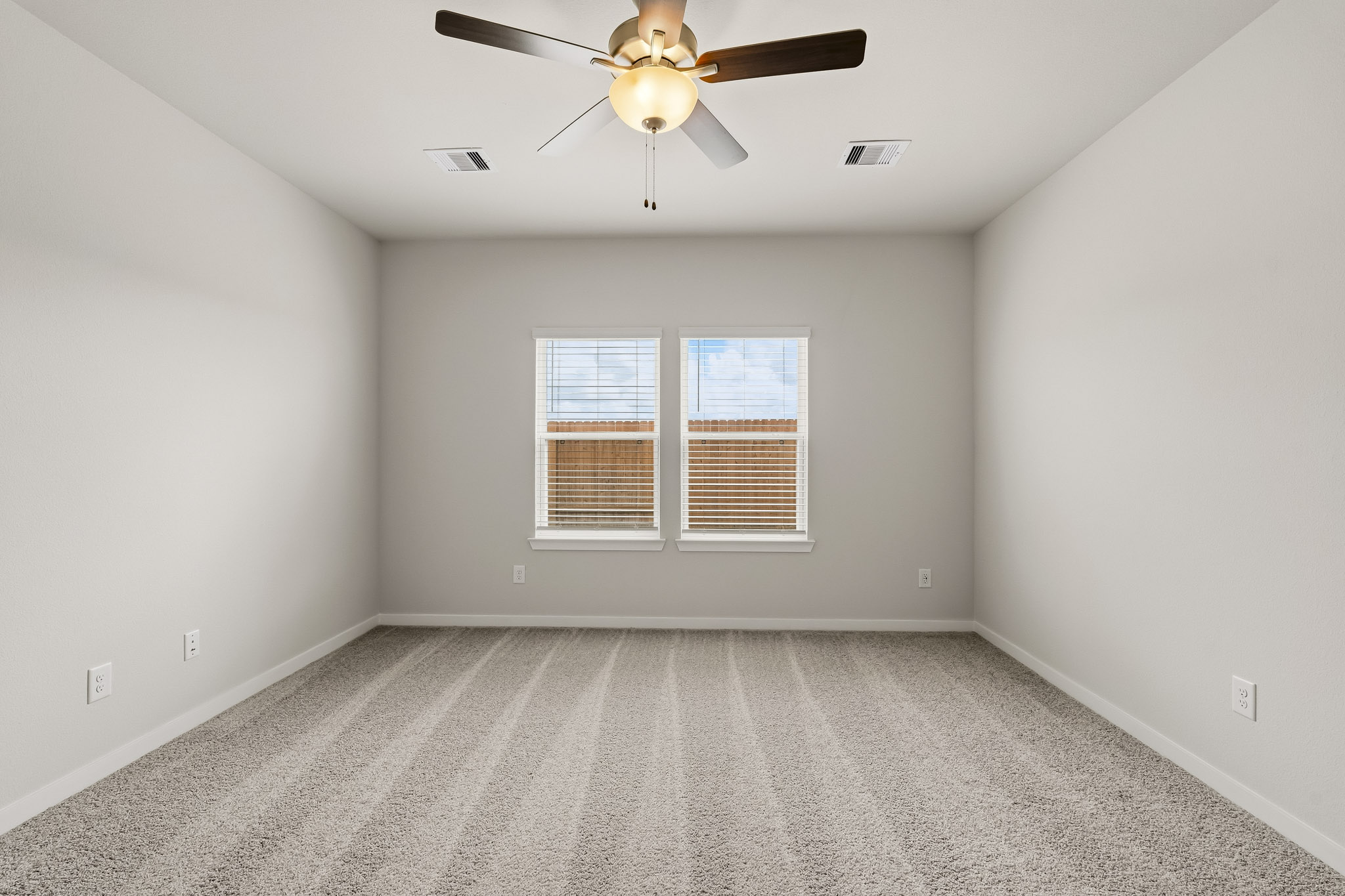 A room with a ceiling fan and a window.