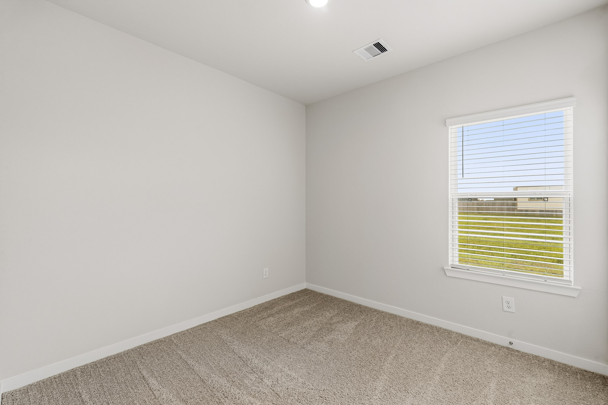 A room with a window and a carpet.