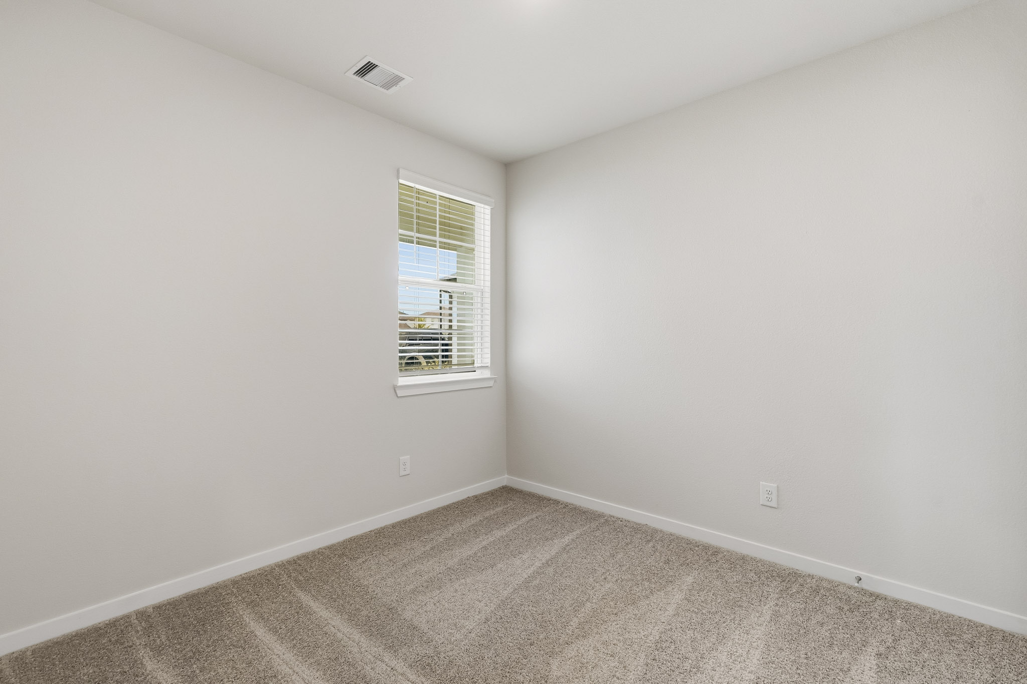 A room with a window and carpet.
