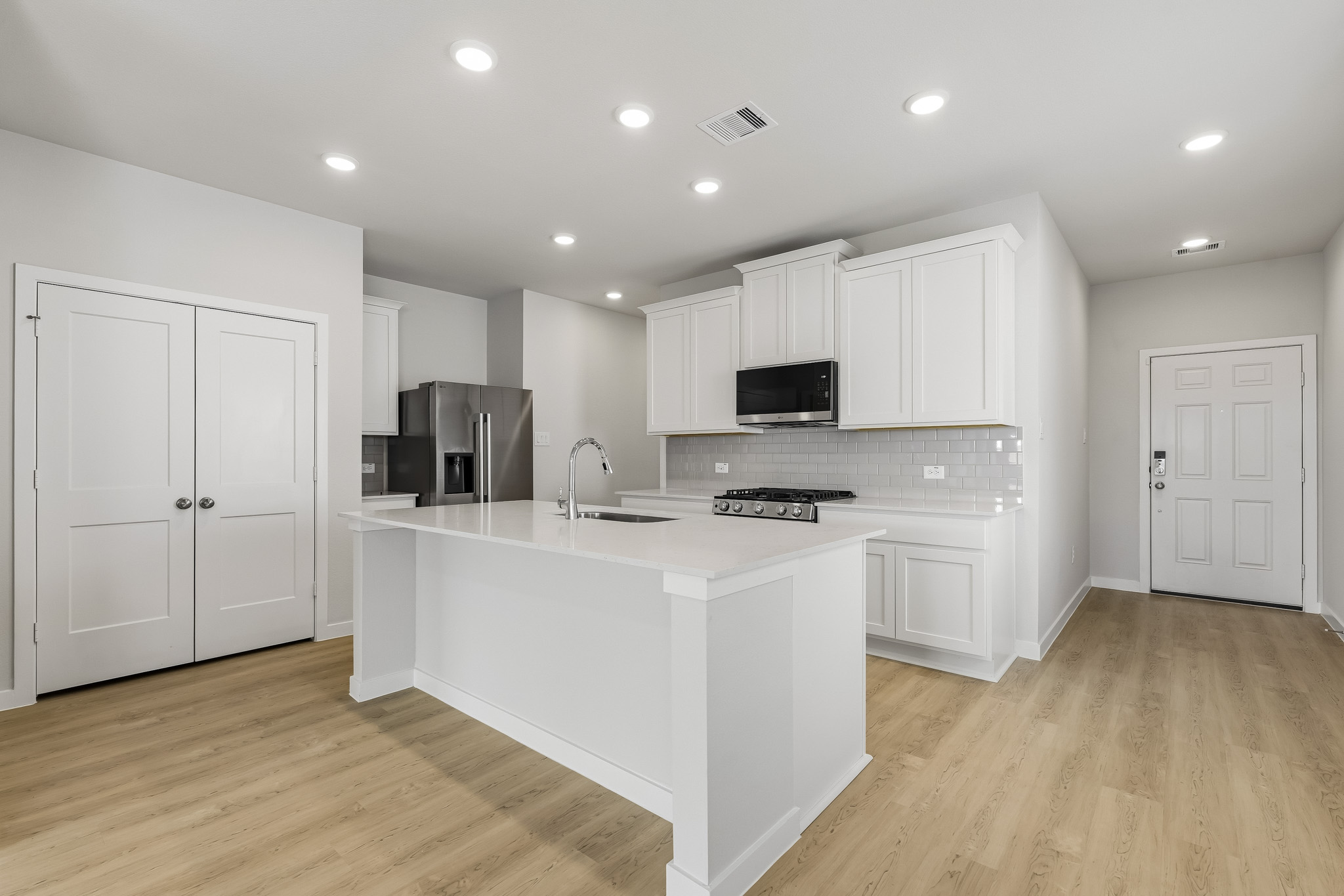A kitchen with white cabinets.