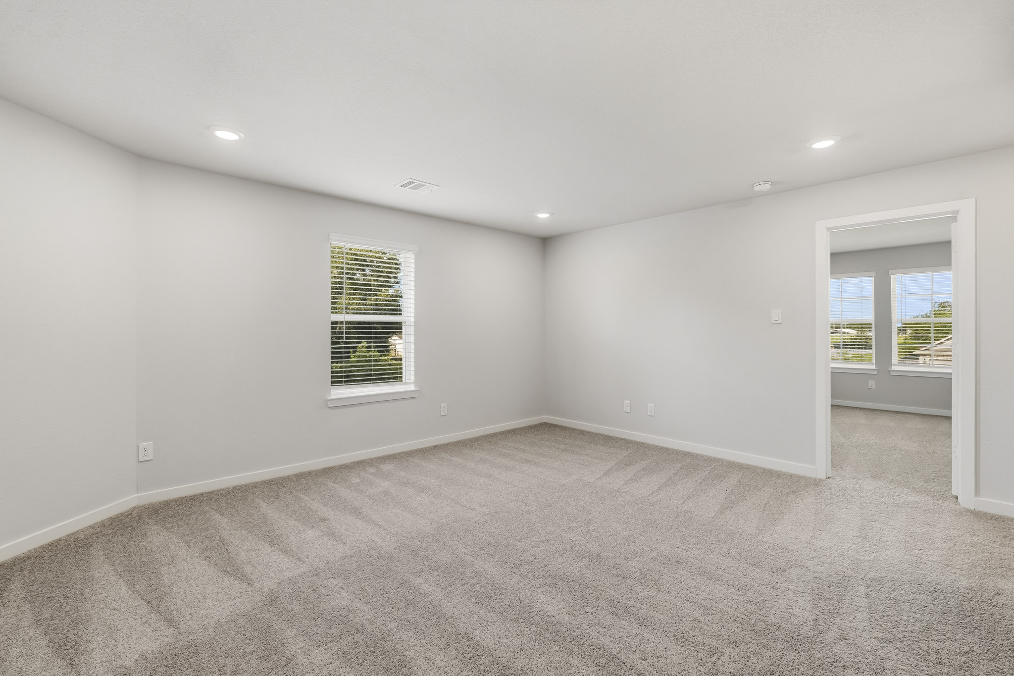 A room with a white wall and windows.