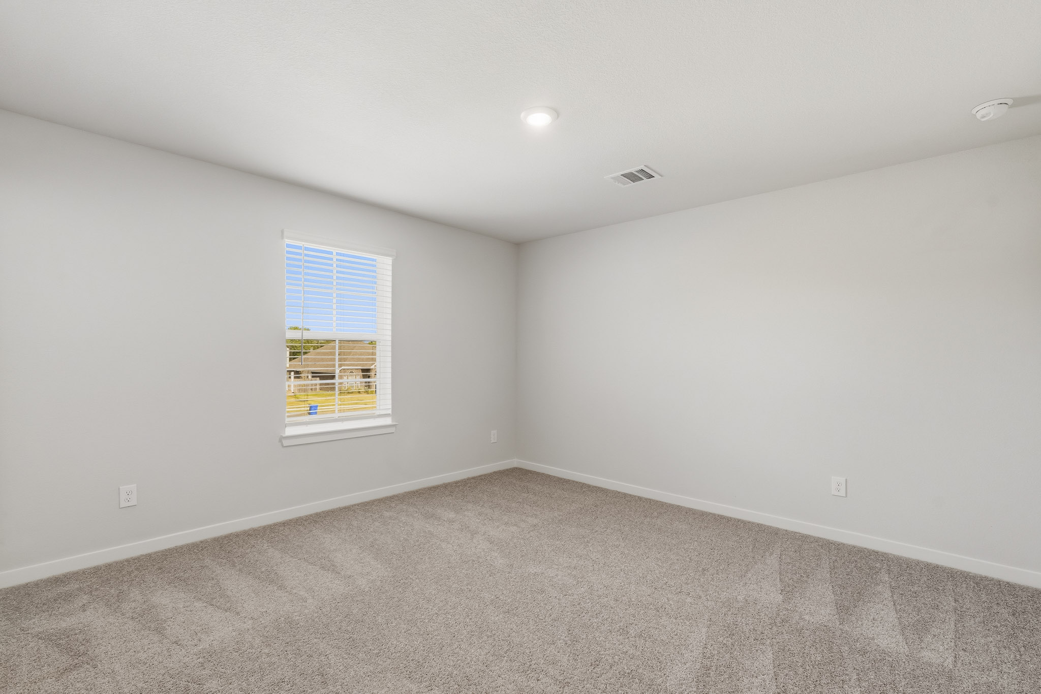 A room with a window and a carpet.