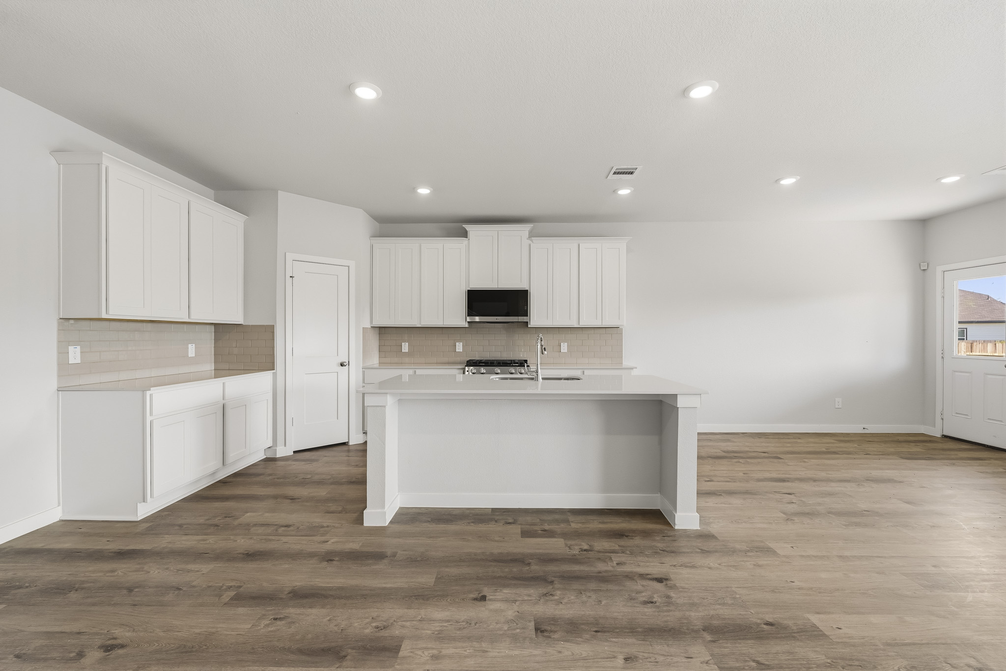 A kitchen with white cabinets.