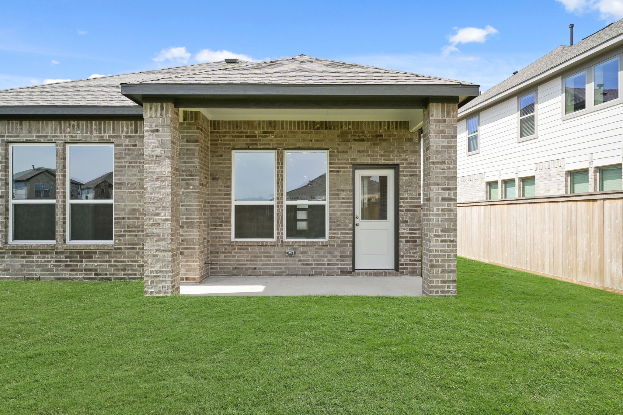 A brick building with a grass yard.