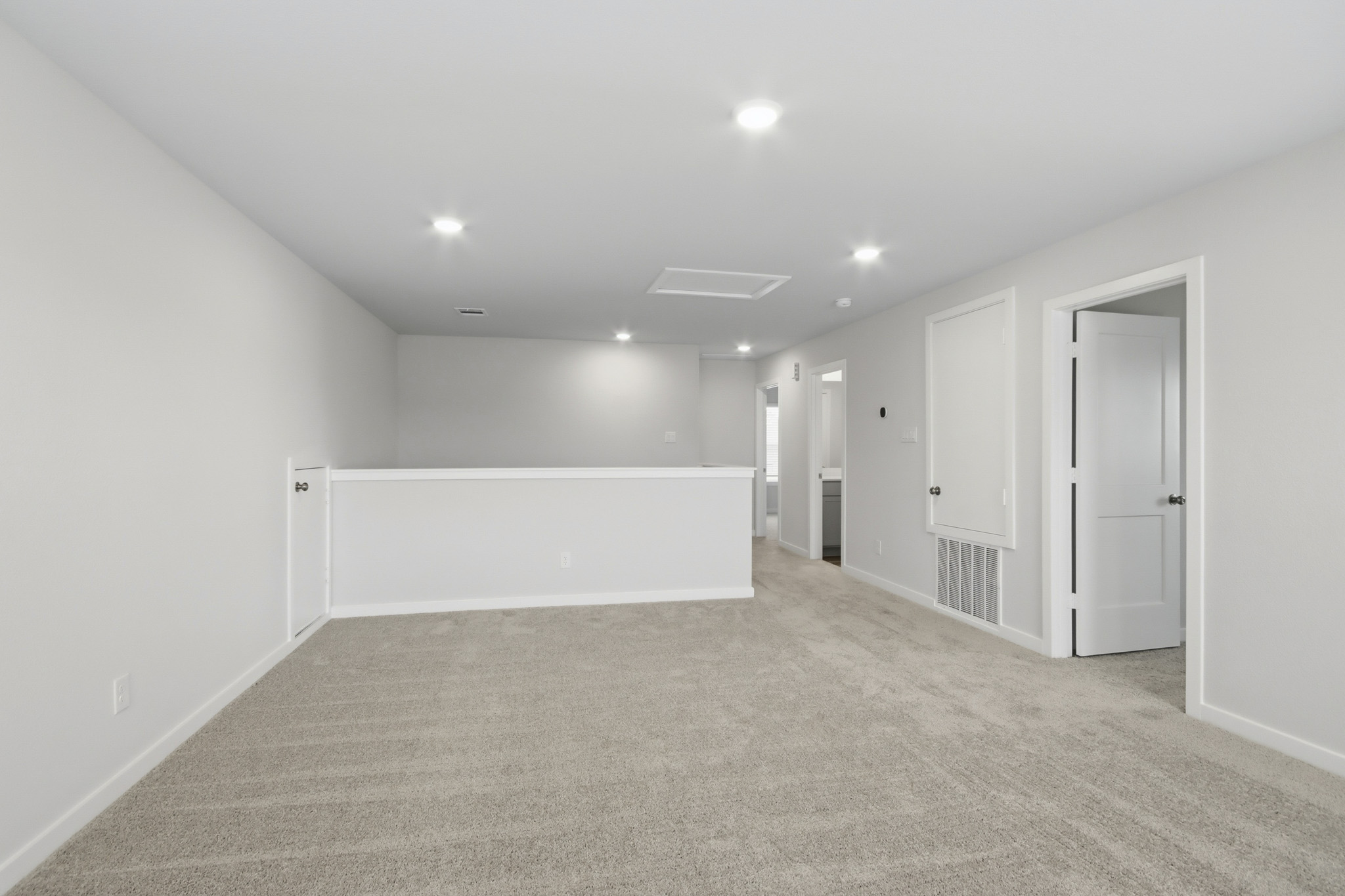 A long hallway with white doors.