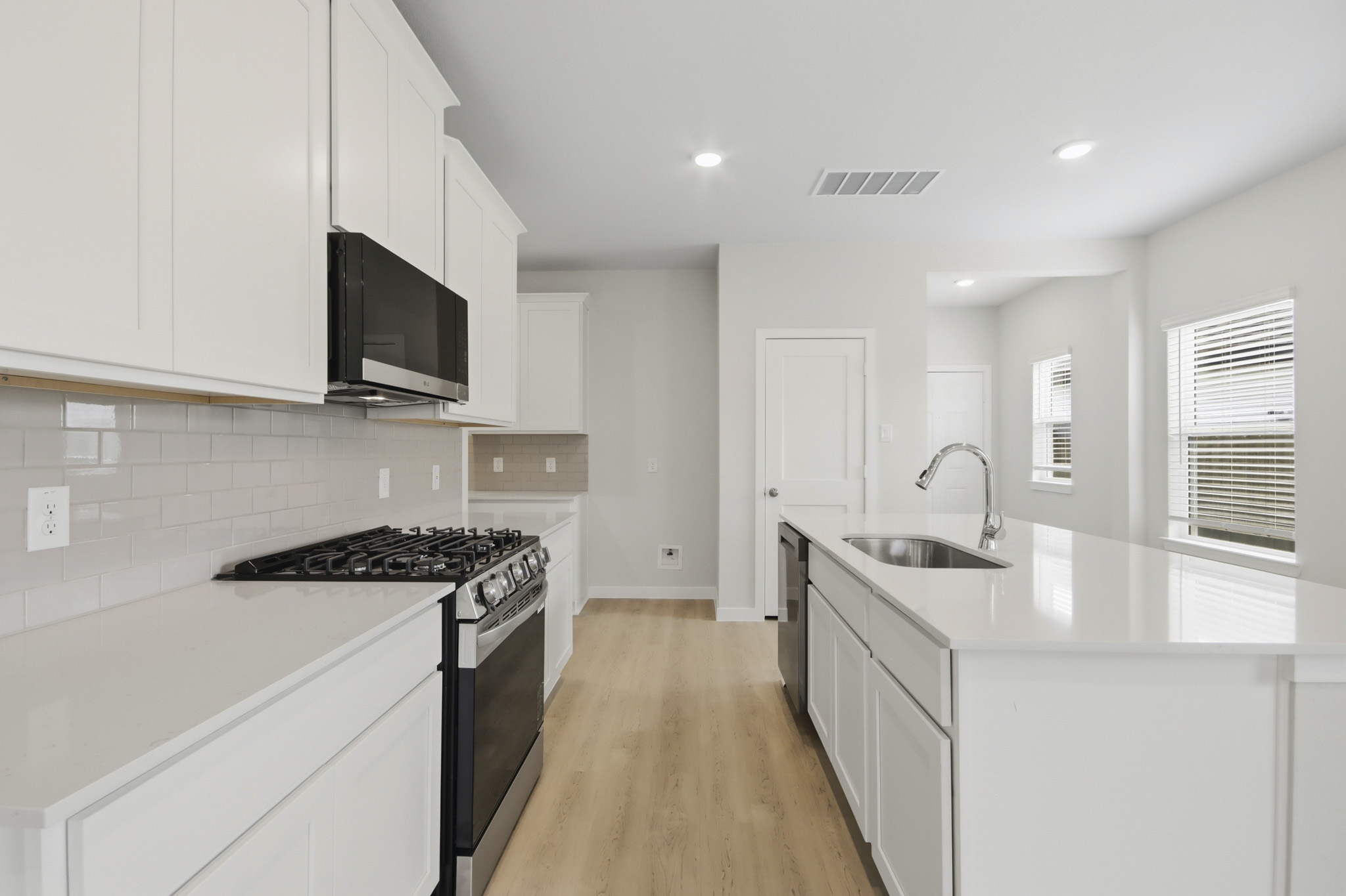 A kitchen with white cabinets.
