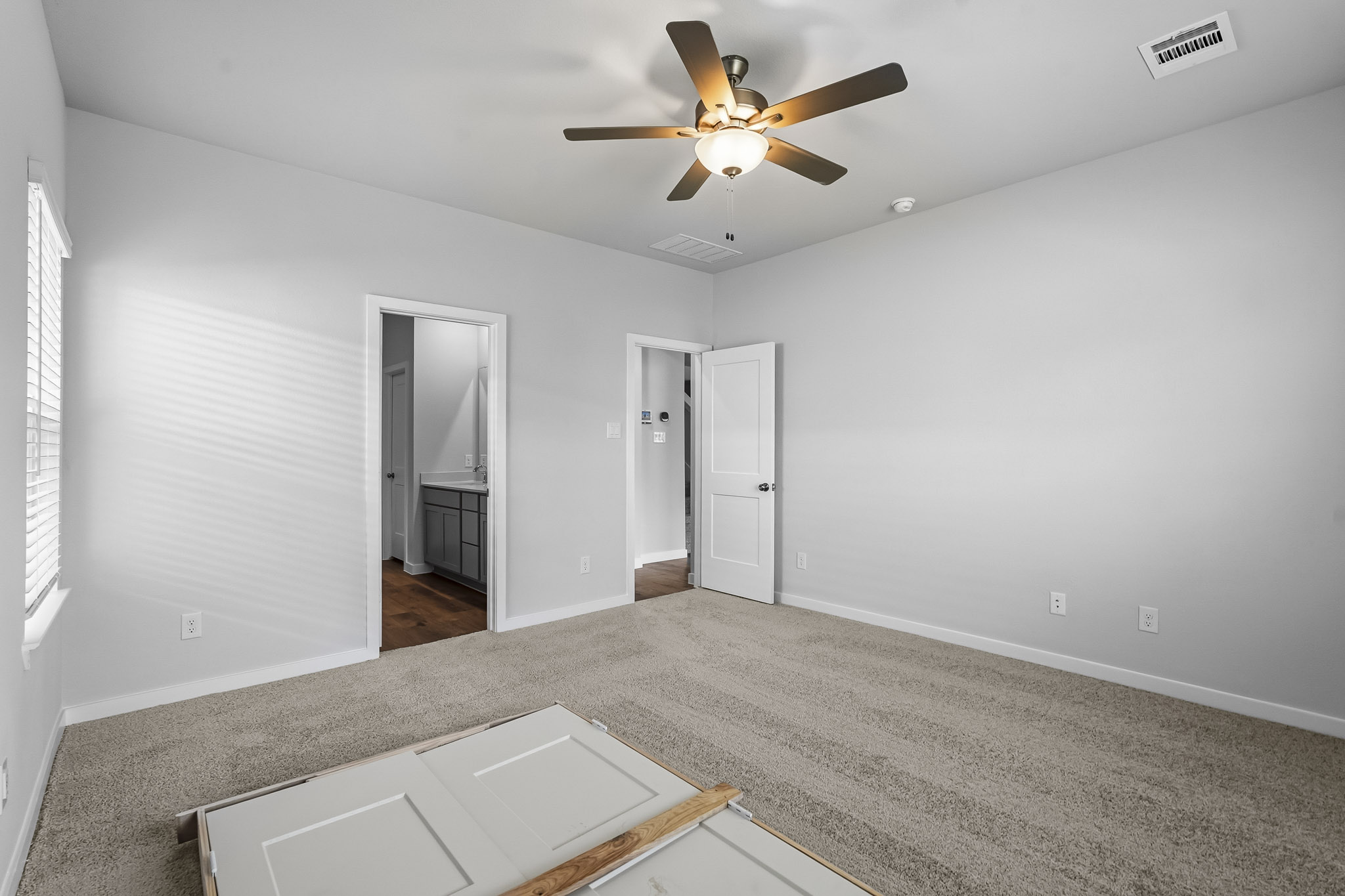 A room with a ceiling fan and a tile floor.