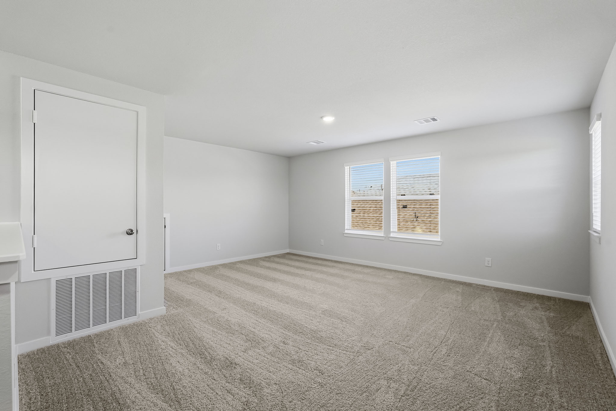 A room with a white wall and a window.