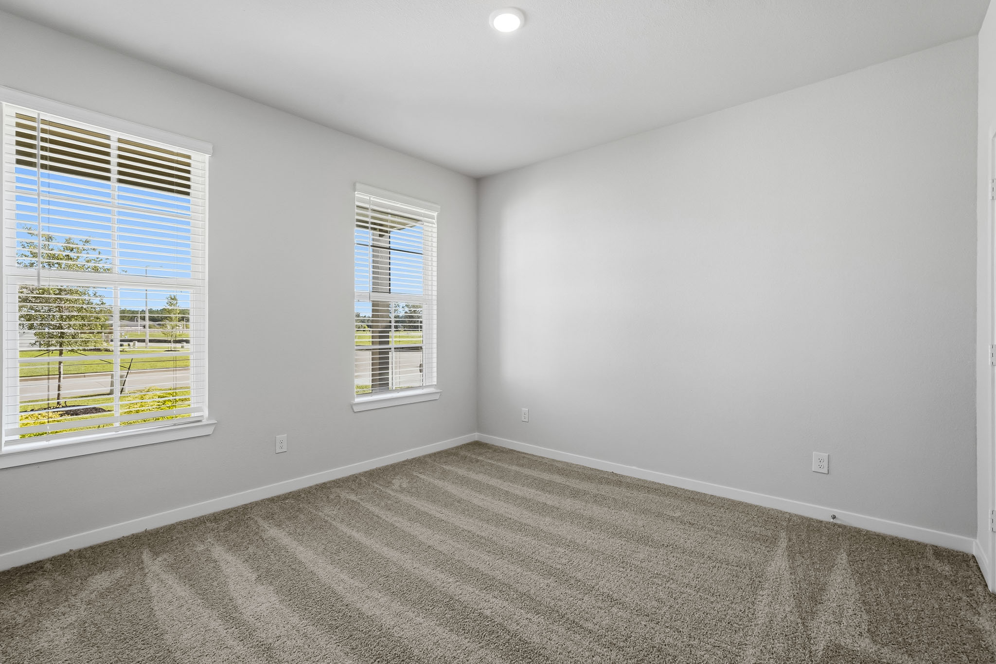 A room with a window and a carpet.