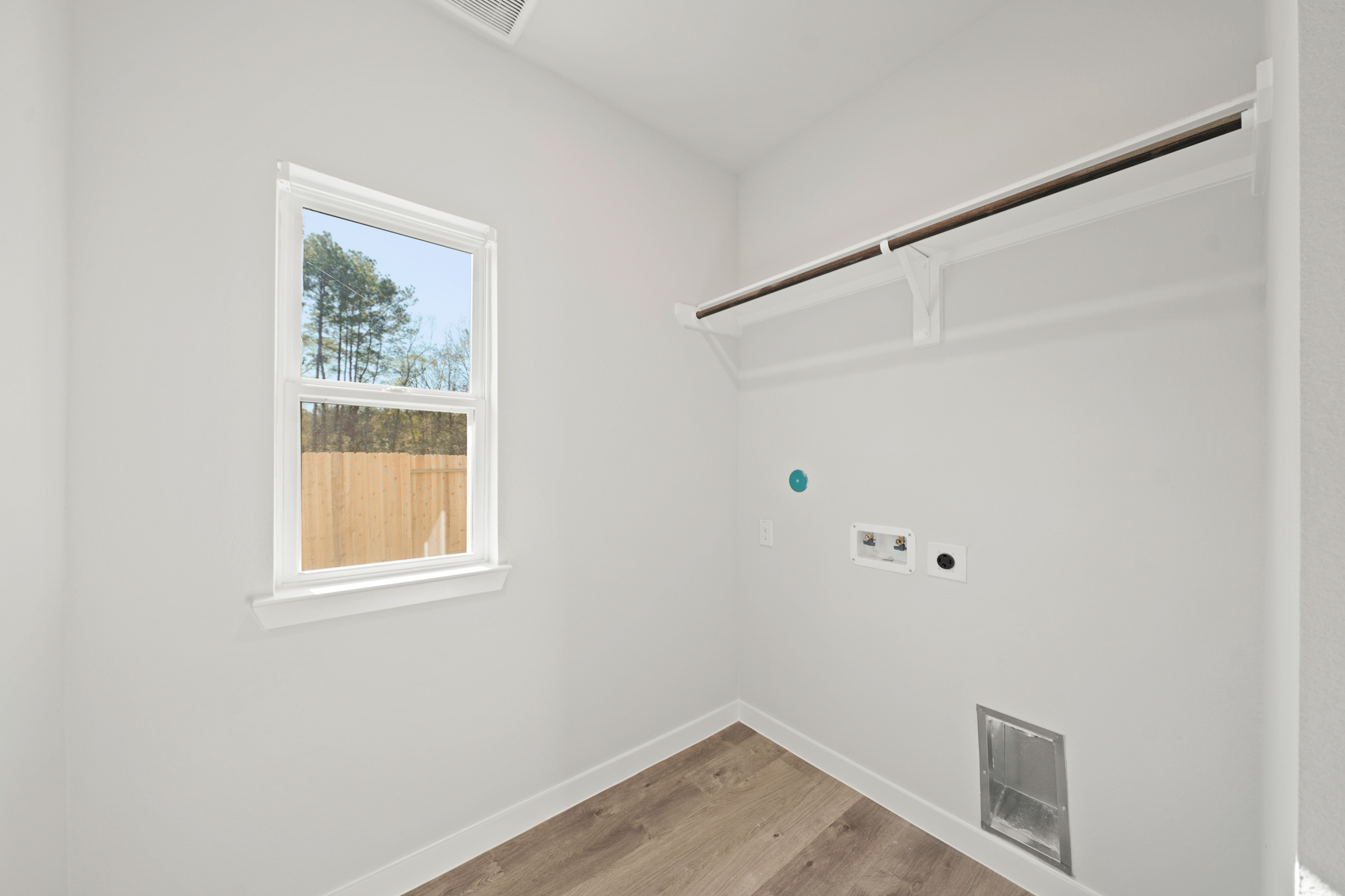 A room with a window and a wood floor.