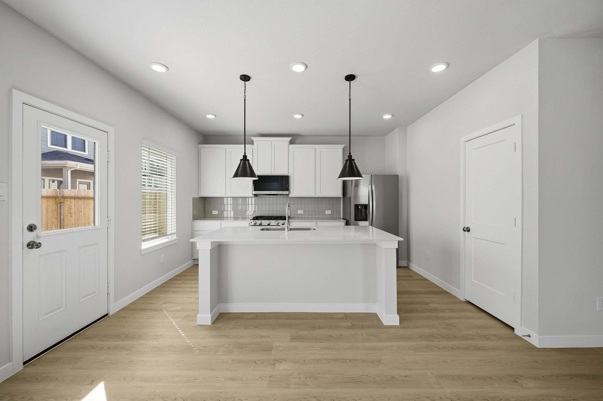 A kitchen with white cabinets.