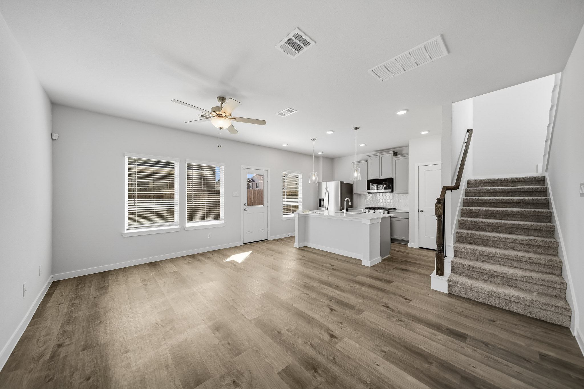 A large empty room with a wood floor and a wood floor.