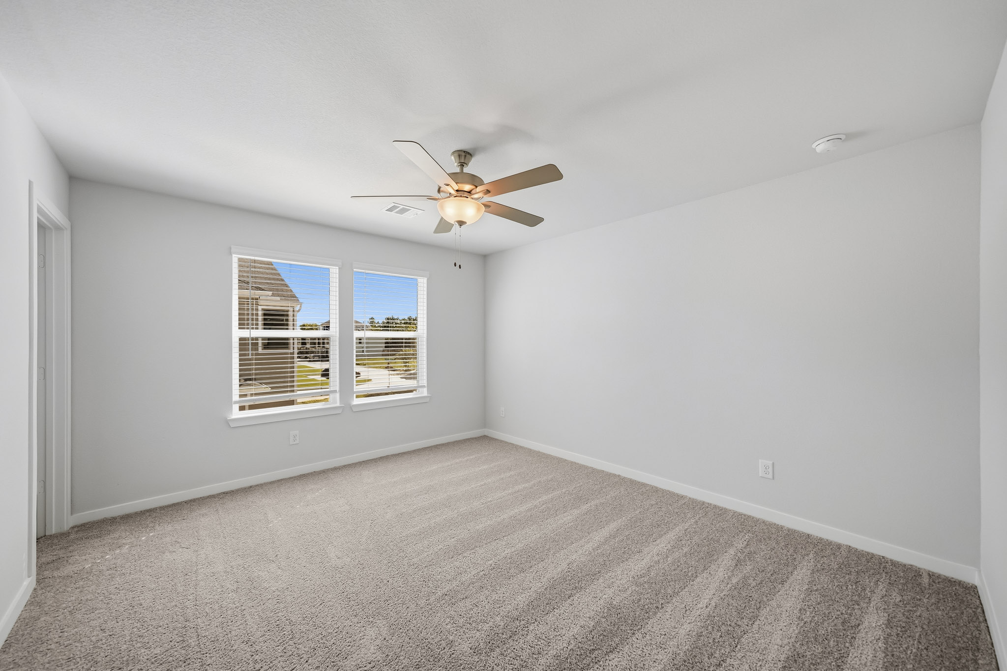 A room with a ceiling fan and a window.