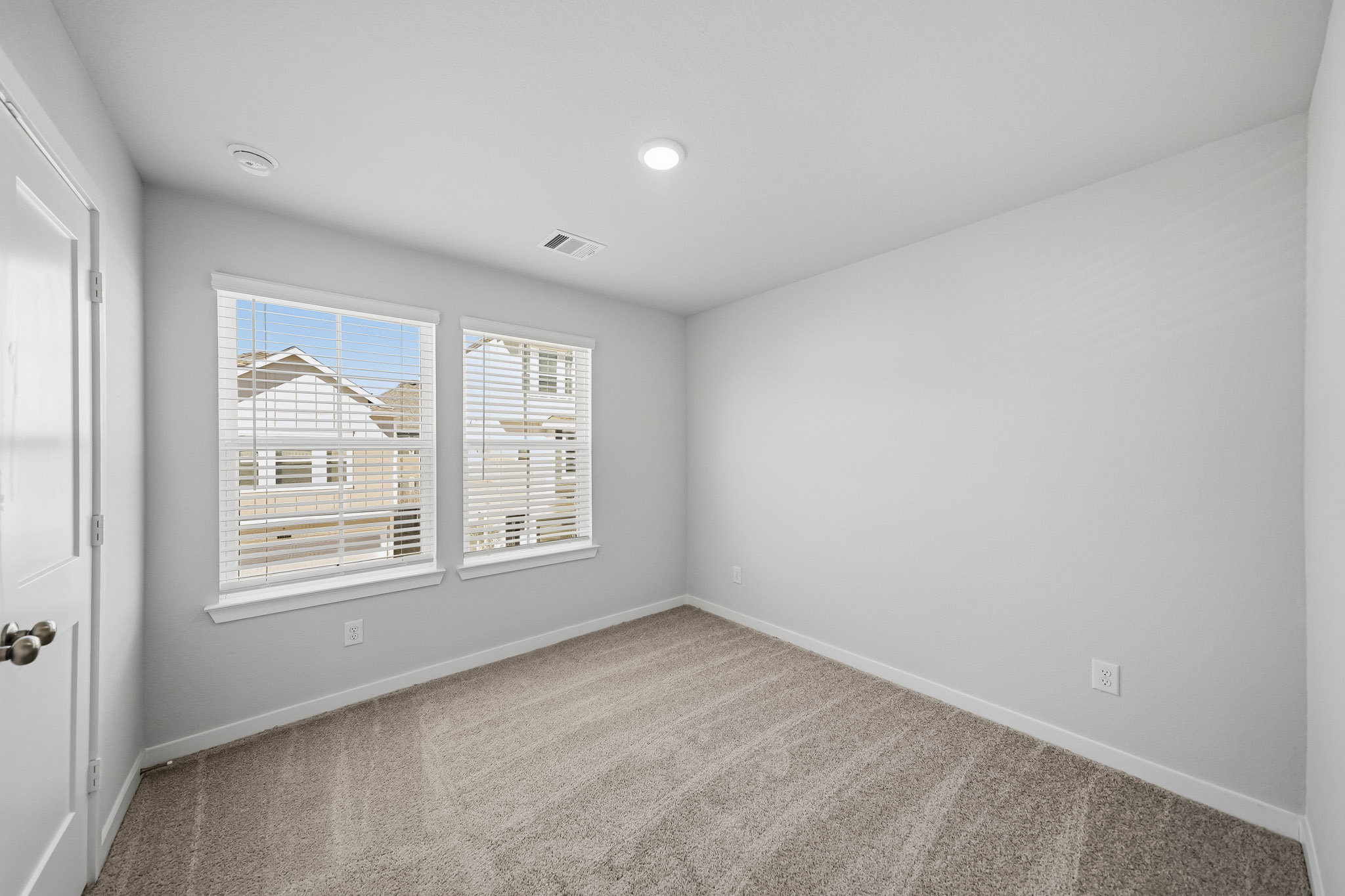 A room with a window and a carpet.