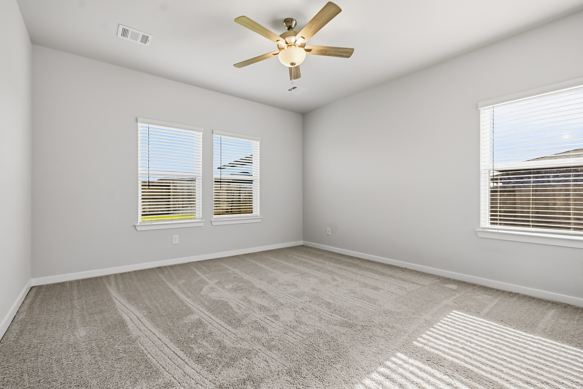 A room with a ceiling fan and a window.