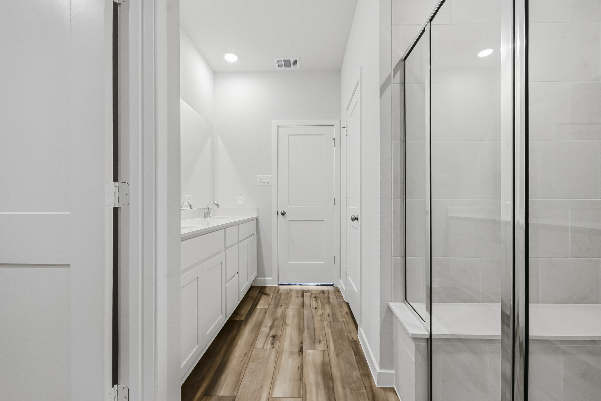 A bathroom with white cabinets.
