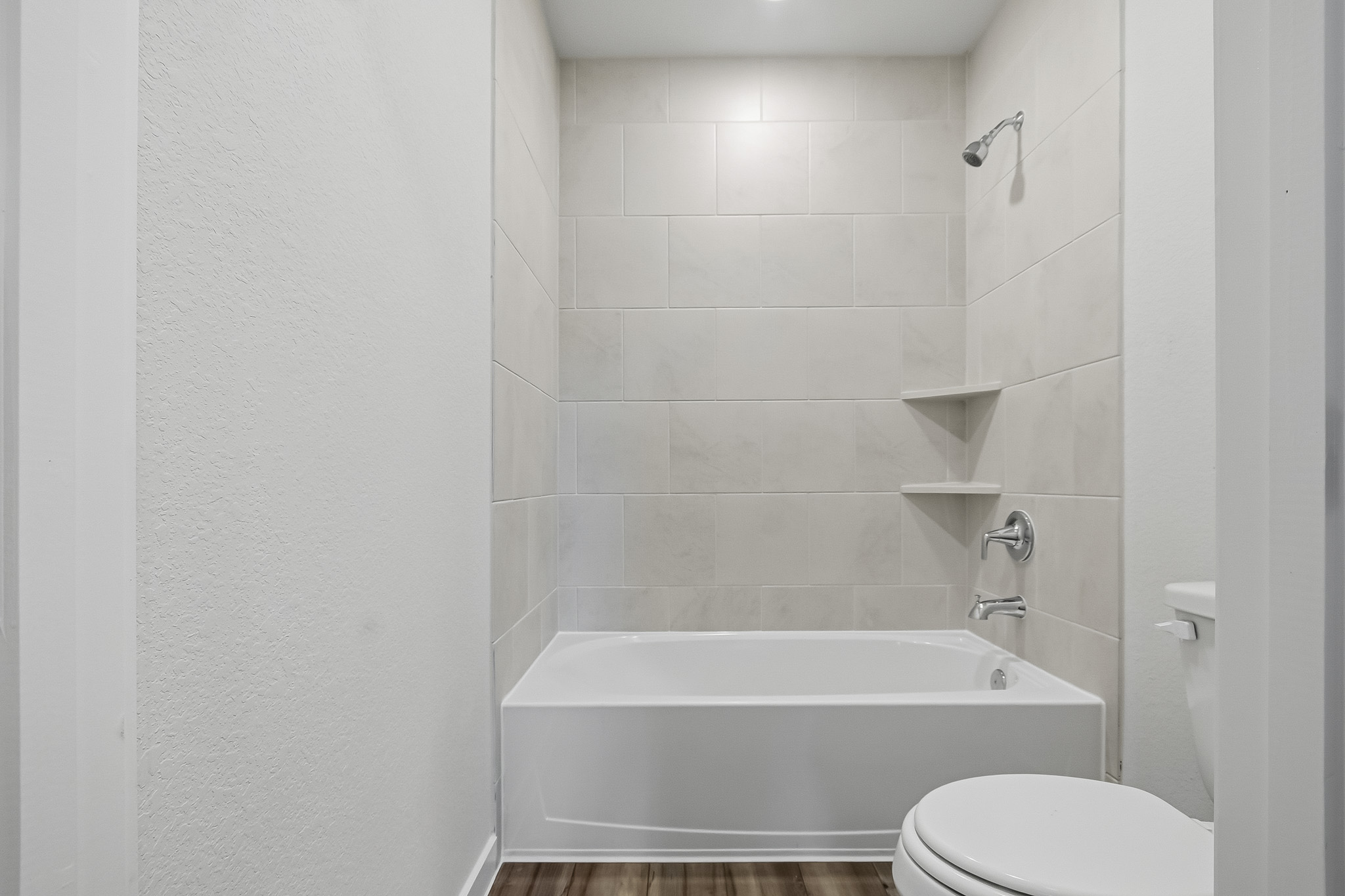 A bathroom with a tub and toilet.
