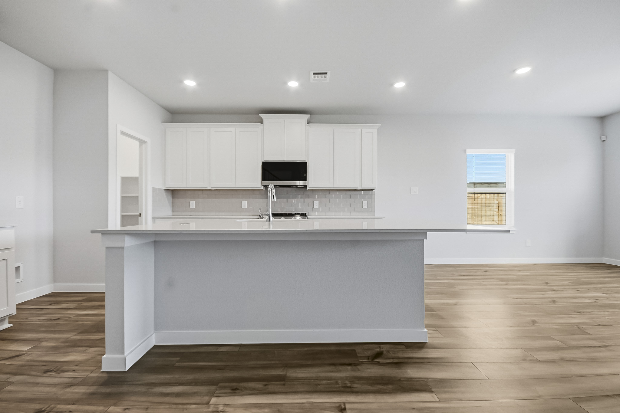 A kitchen with white cabinets.