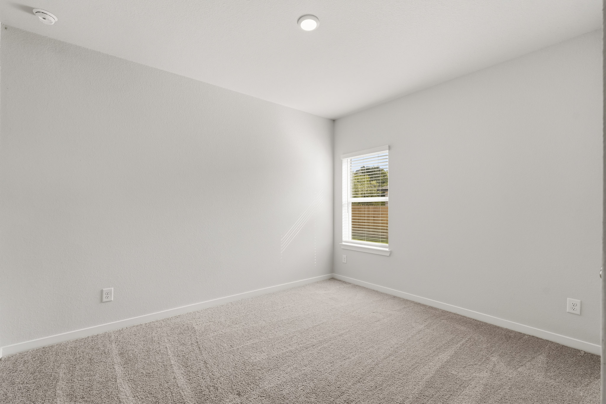 A room with a window and carpet.