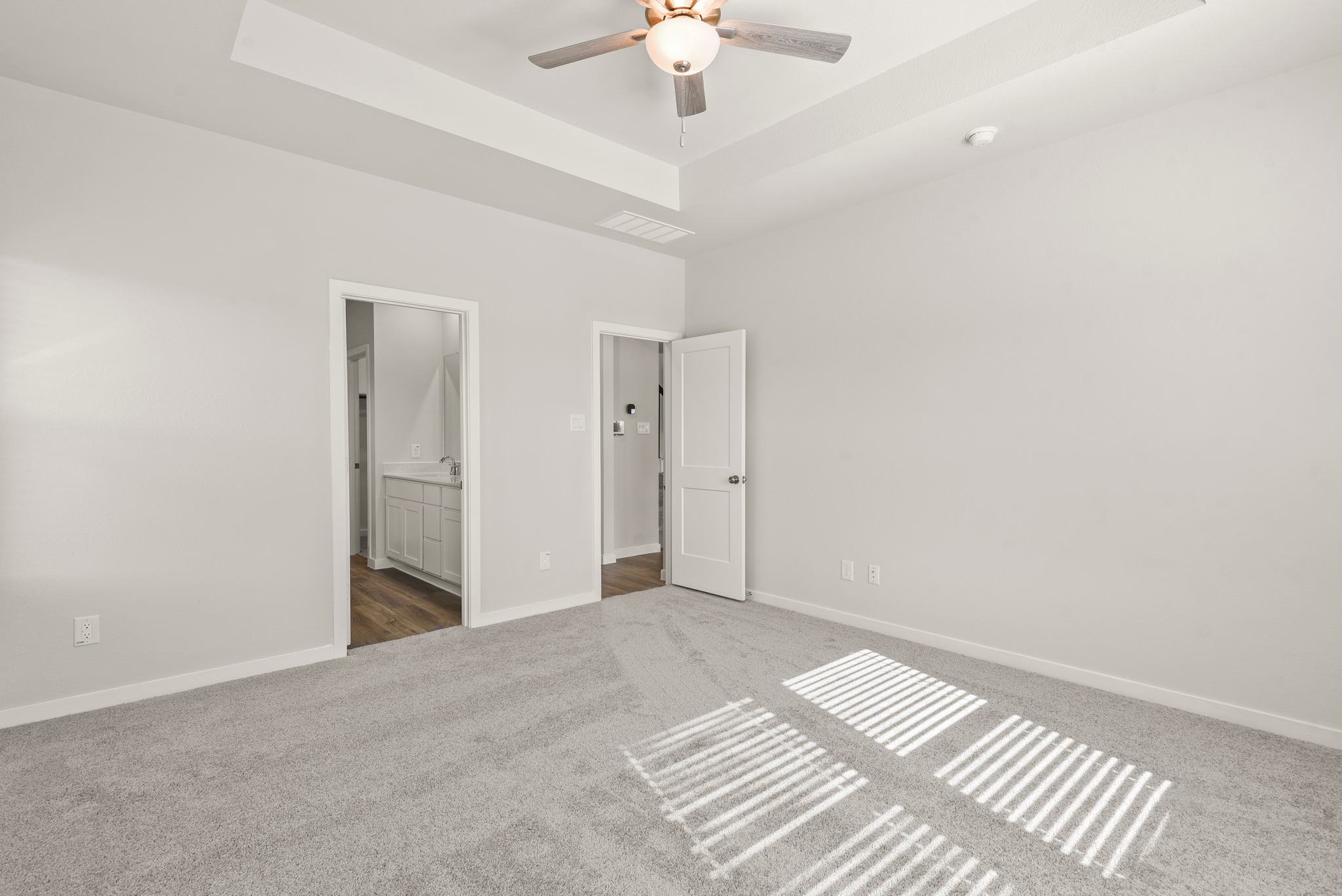 A room with a fan and a rug.