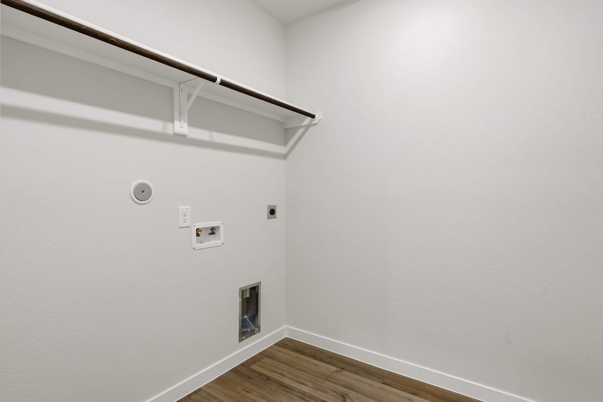 A white room with a wood floor and a wood floor.