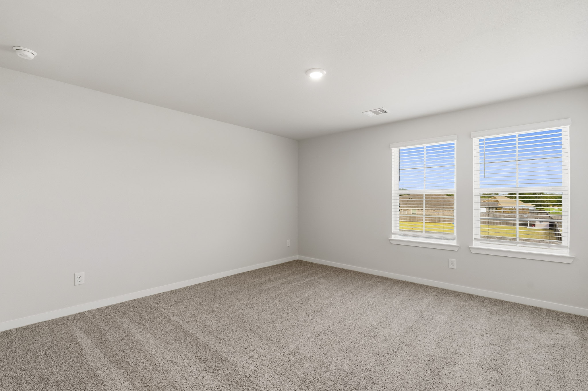 A room with windows and a carpet.