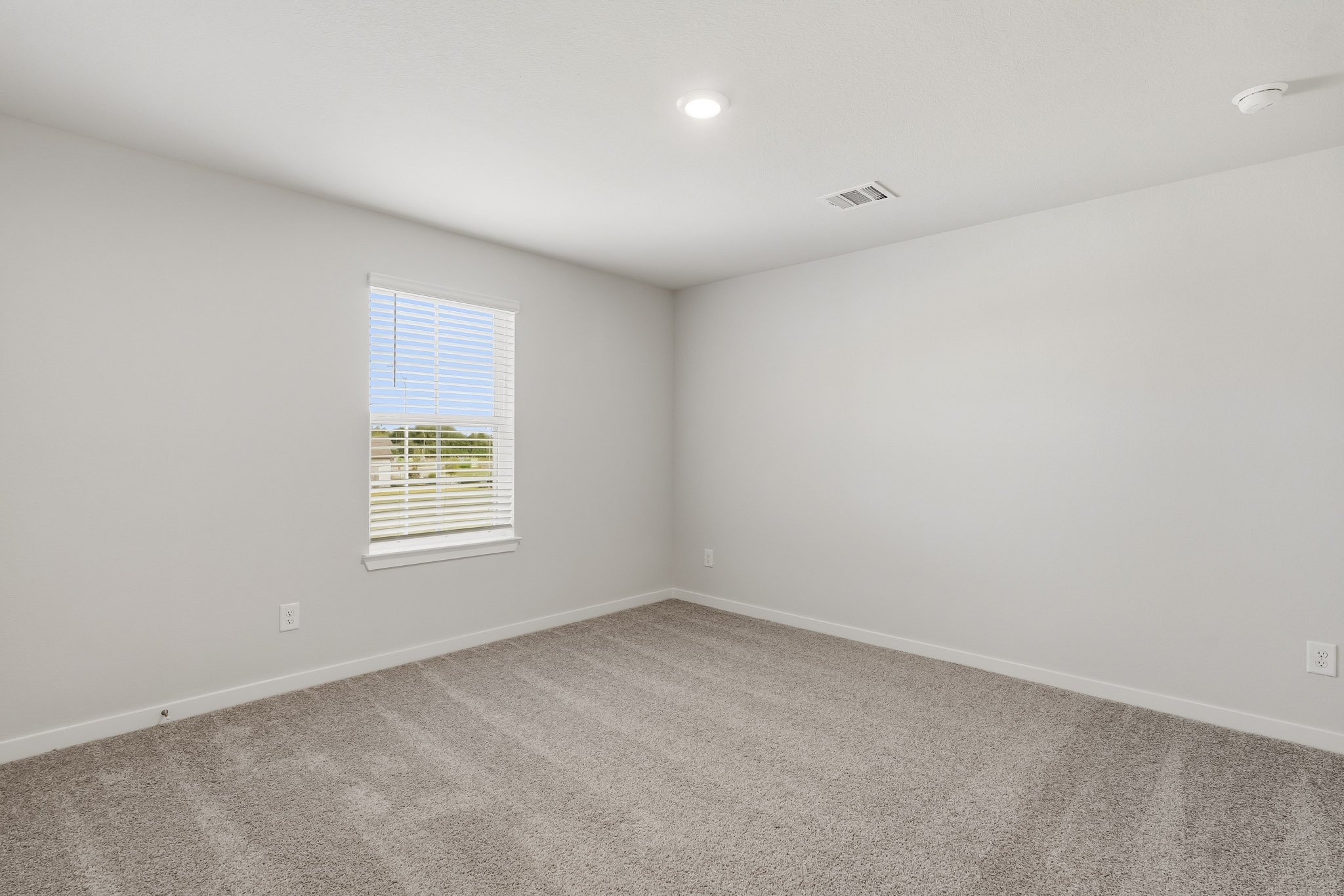 A room with a window and a carpet.