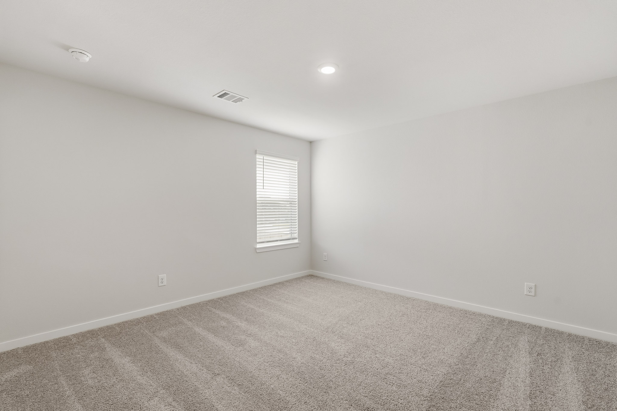 A room with a window and a carpet.