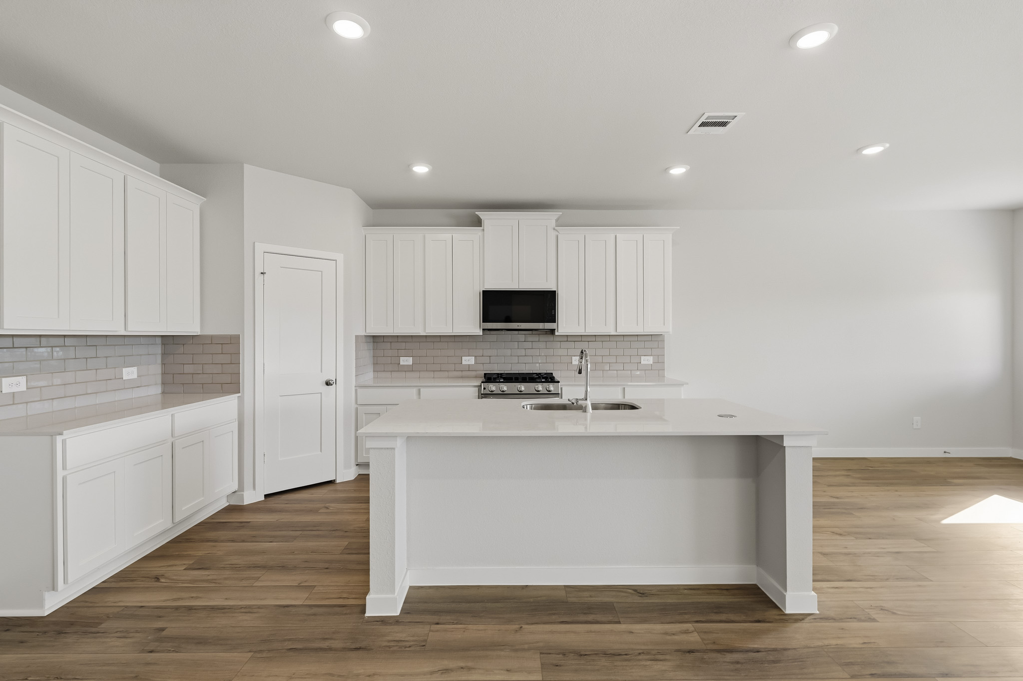 A kitchen with white cabinets.