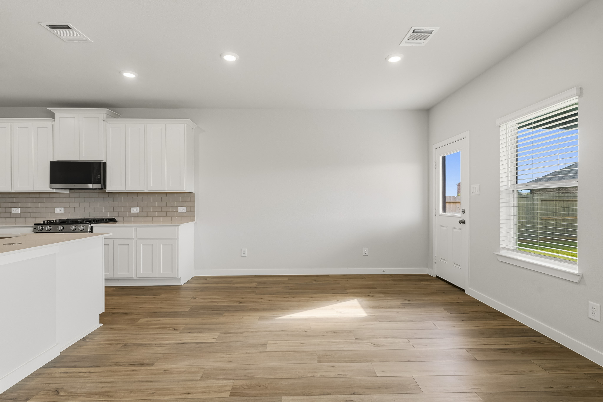 A kitchen with white cabinets.