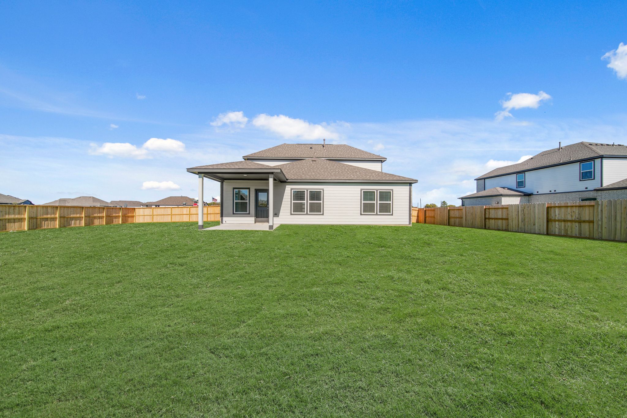 A large green lawn in front of a house.