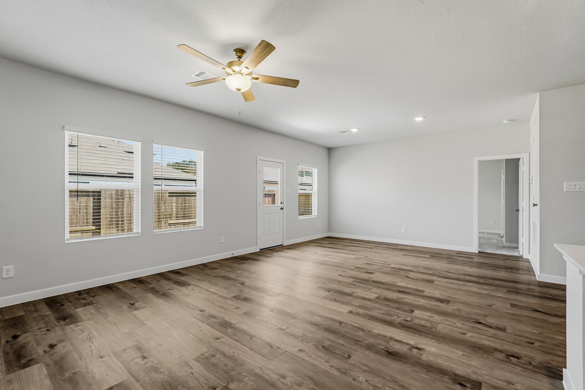 A room with a wood floor and a ceiling fan.