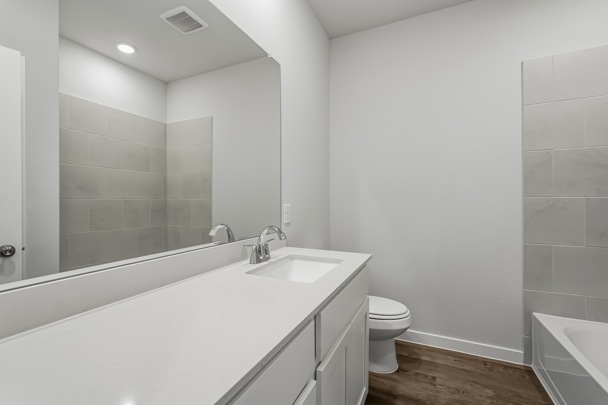 A bathroom with a tub sink and toilet.