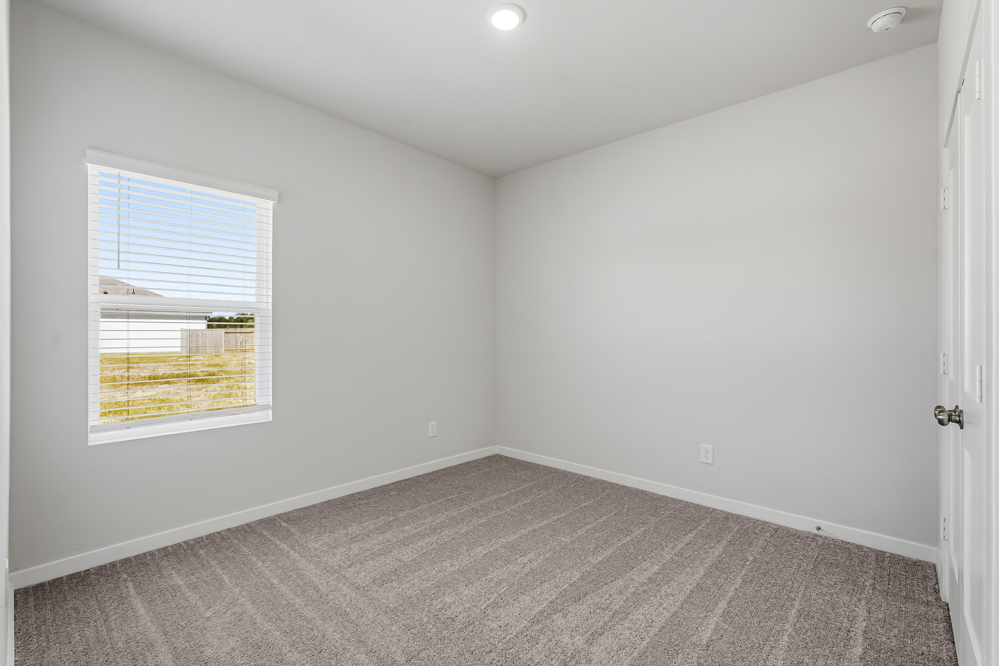 A room with a window and a carpet.