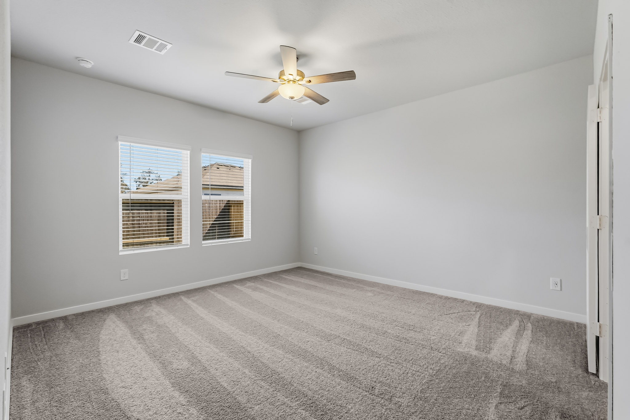 A room with a ceiling fan and a window.