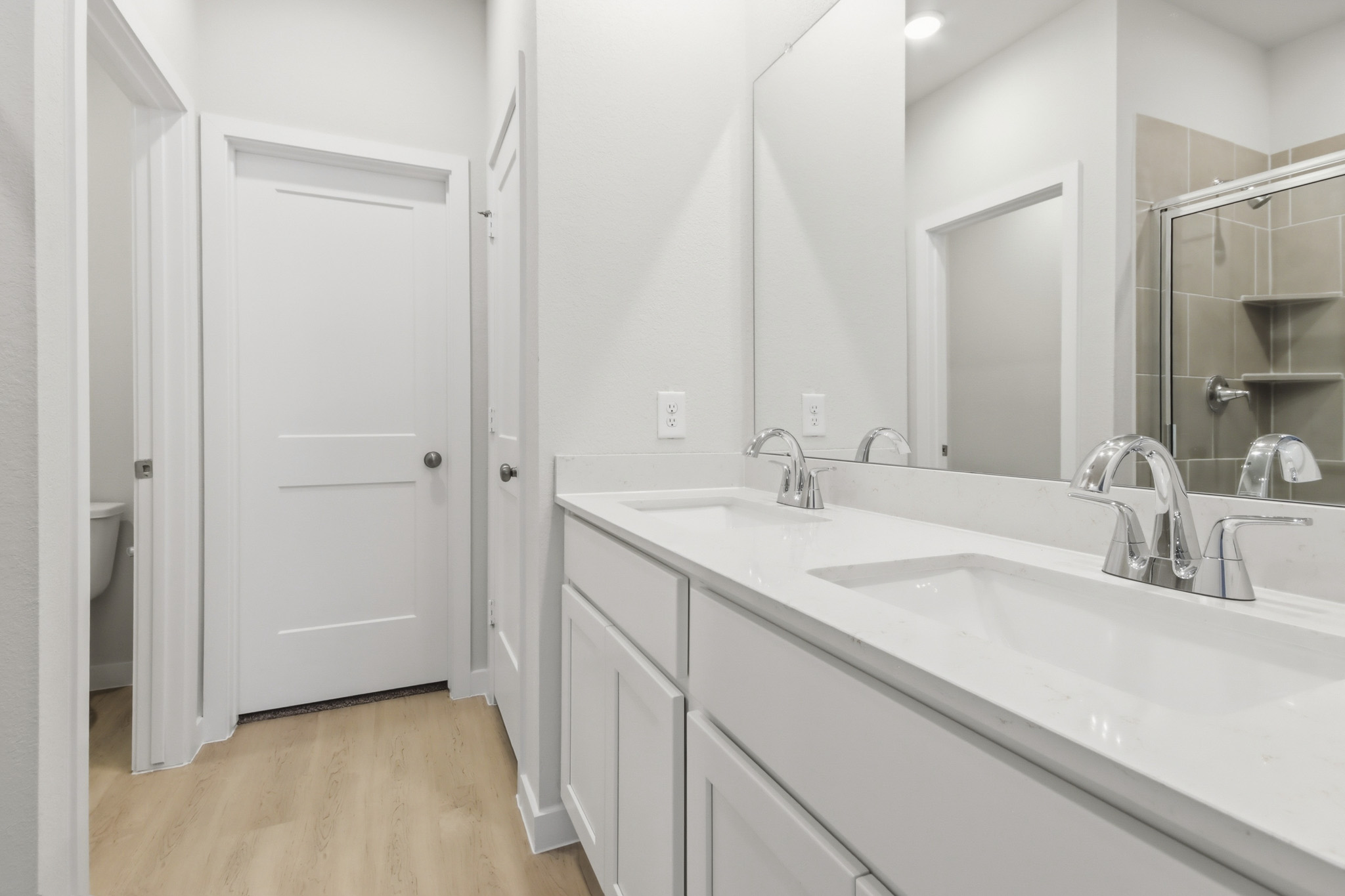A bathroom with white cabinets.