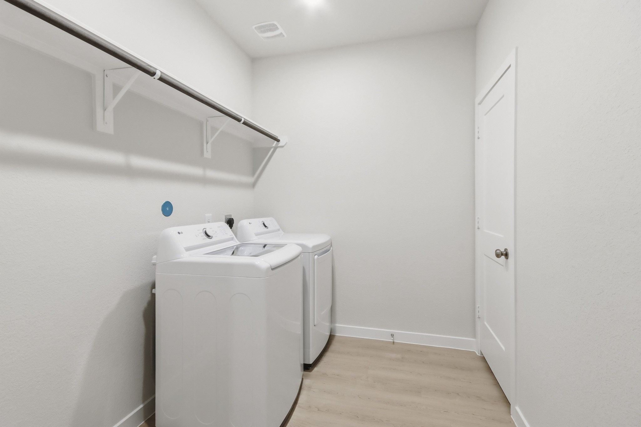 A room with a washing machine and a door.