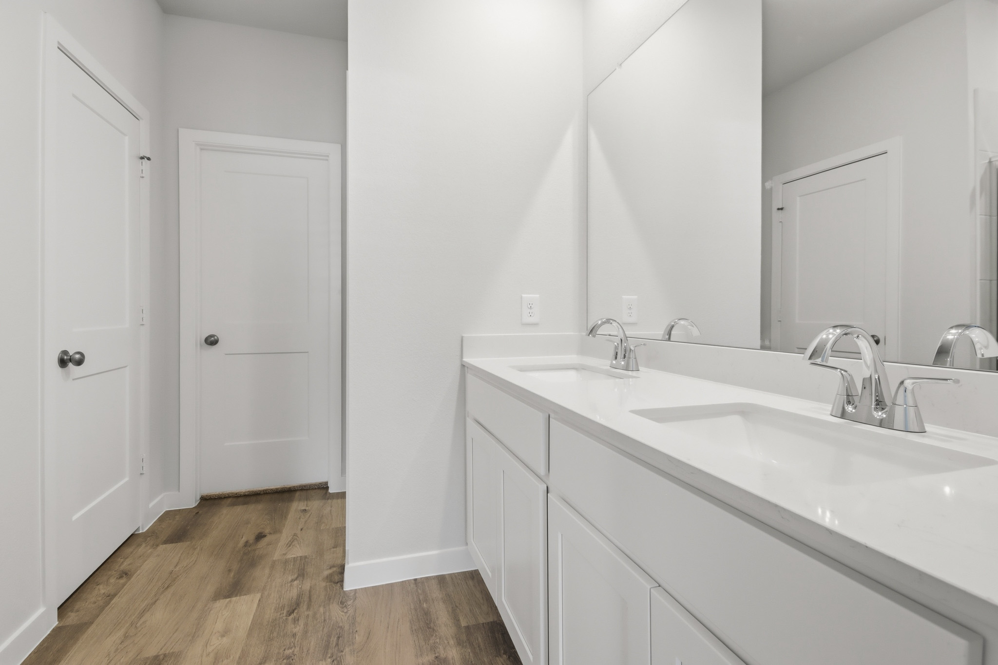 A bathroom with white cabinets.
