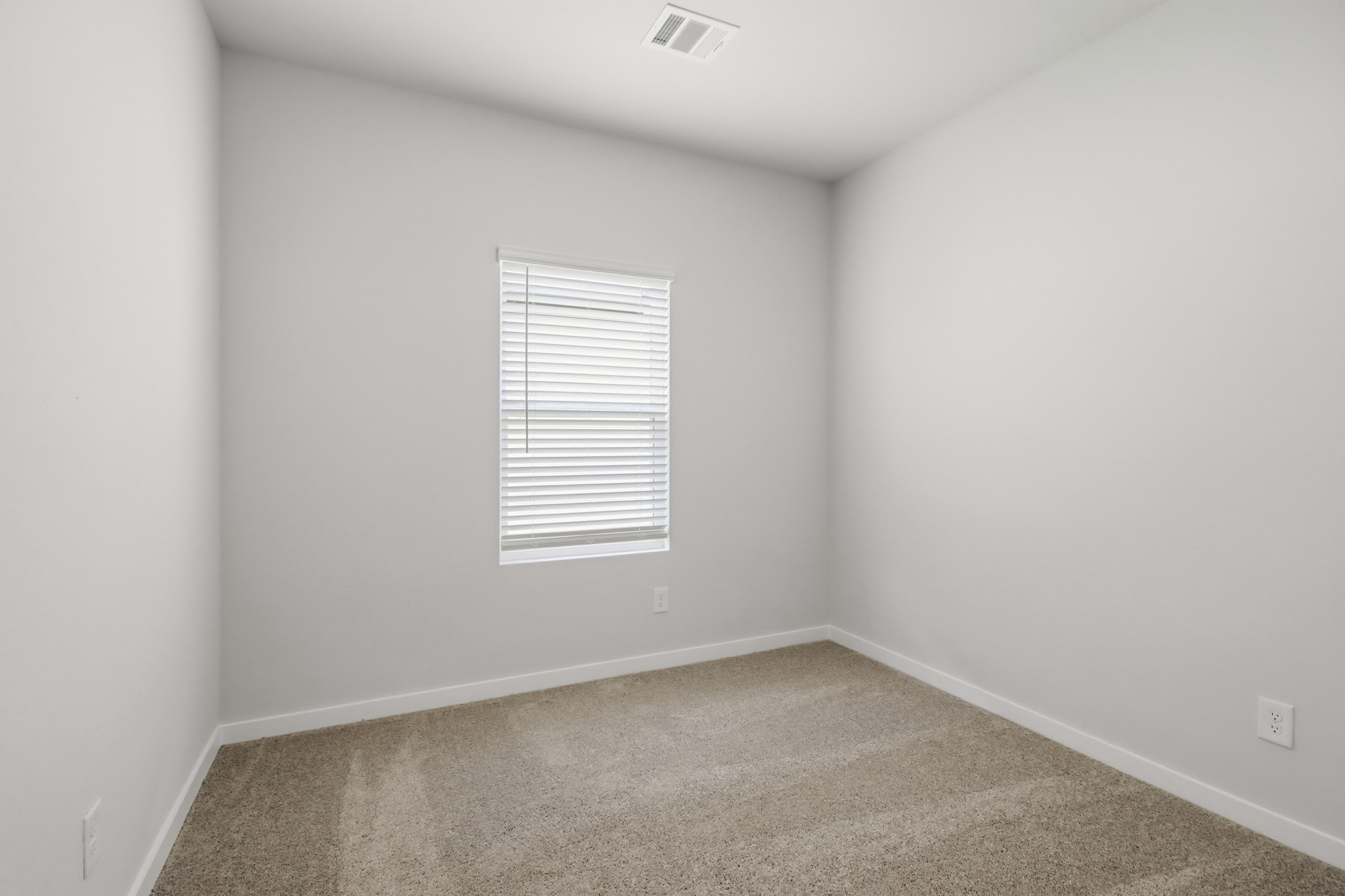 A room with a window and carpet.
