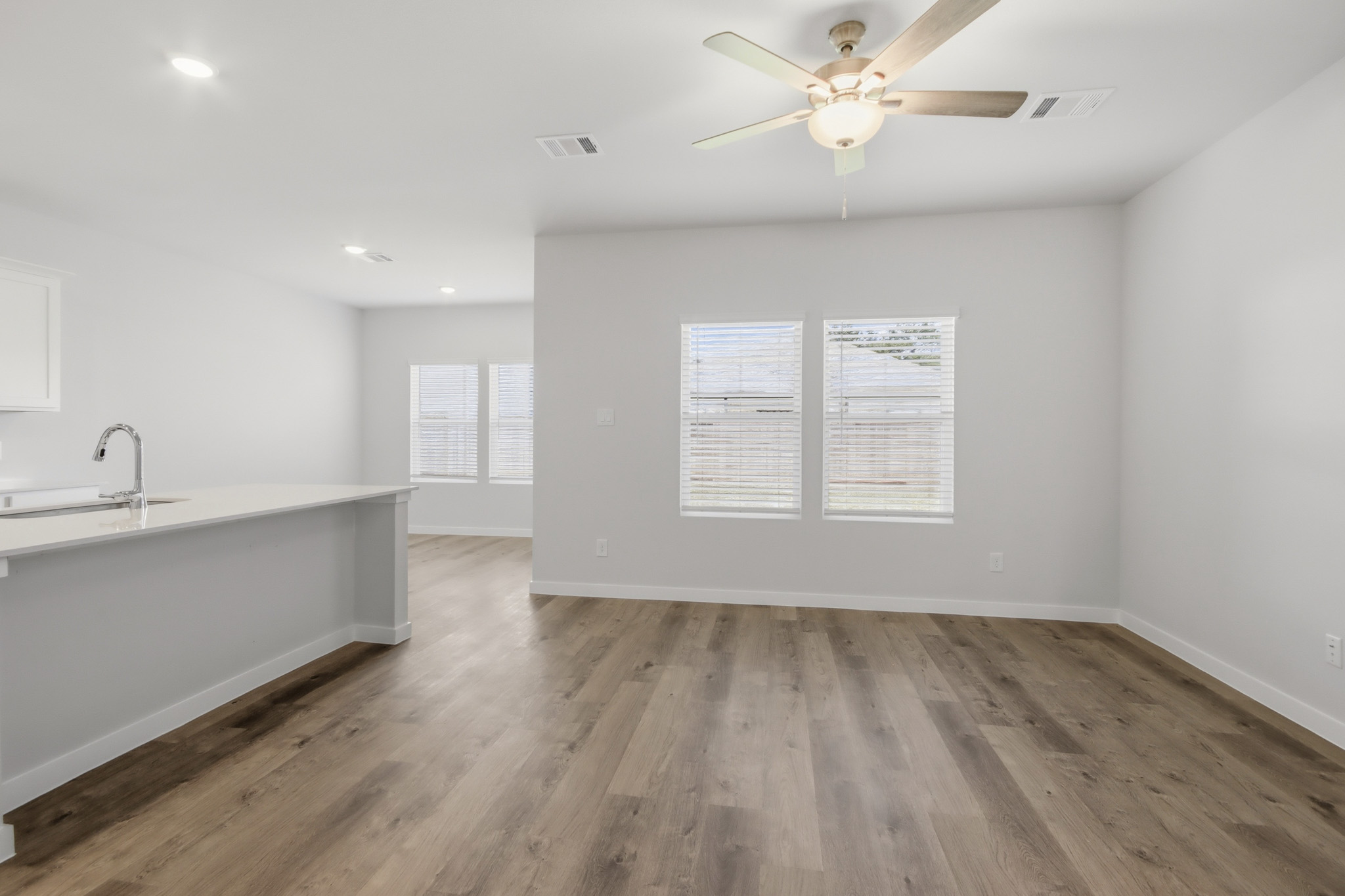 A room with a wood floor and a ceiling fan.