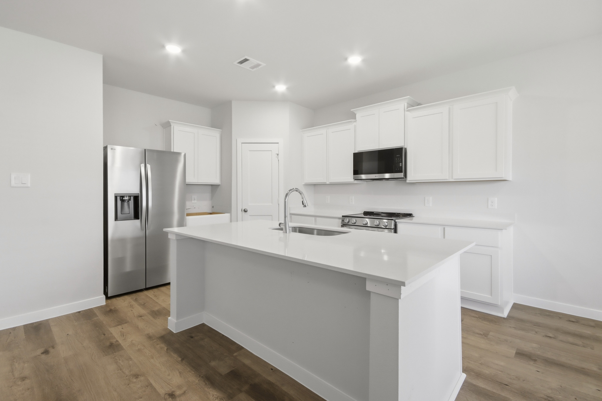 A kitchen with white cabinets.