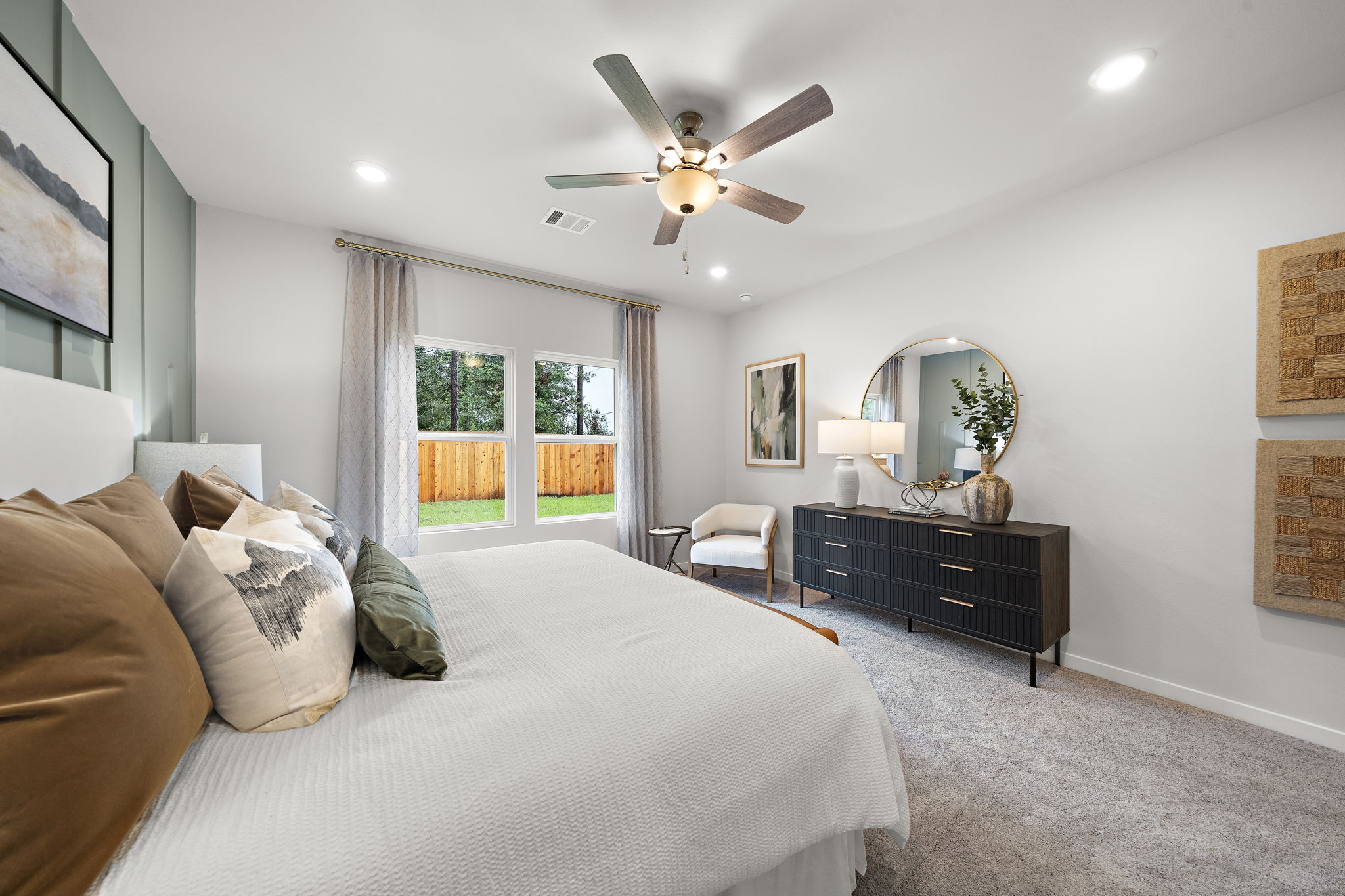 A bedroom with a large bed and a fan.