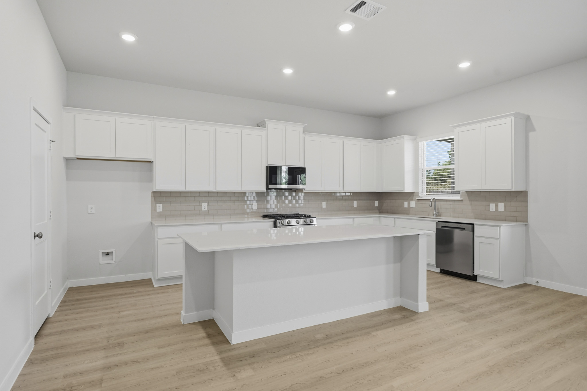 A kitchen with white cabinets.