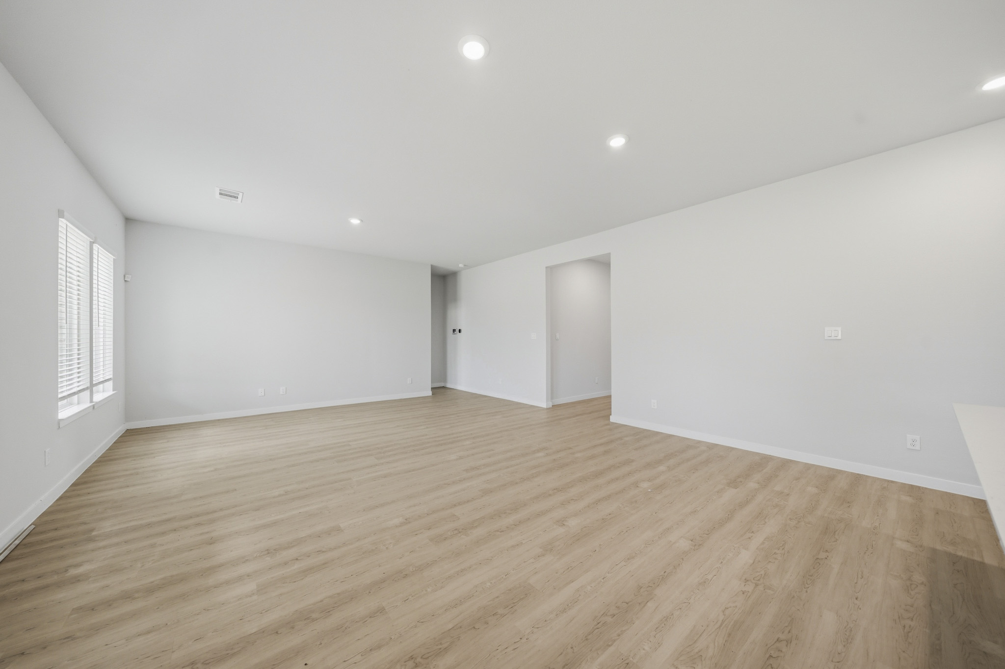 A room with a wood floor and white walls.