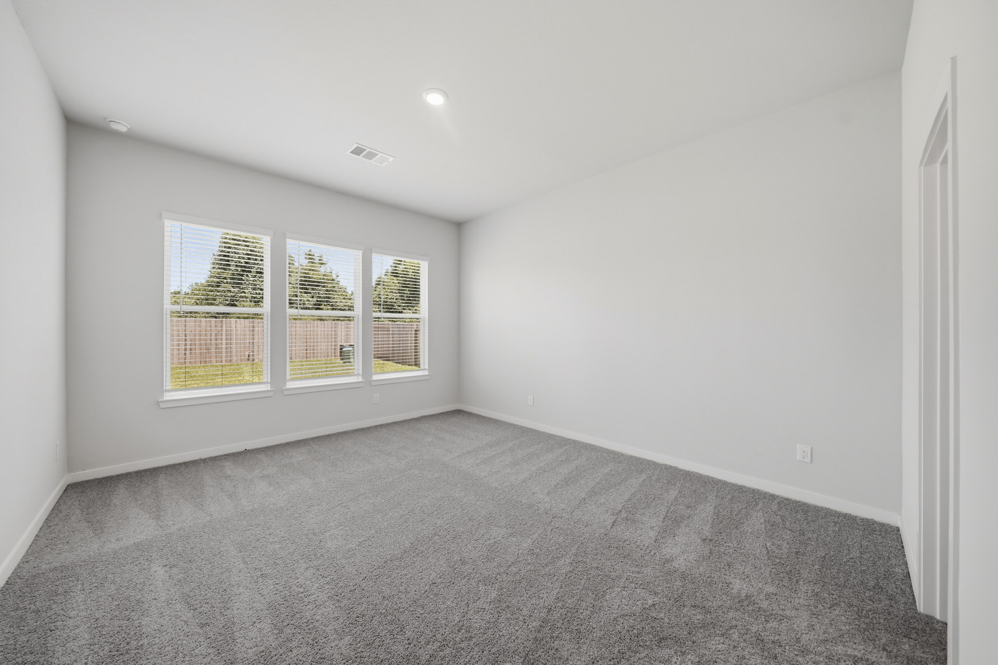 A room with a carpet and windows.